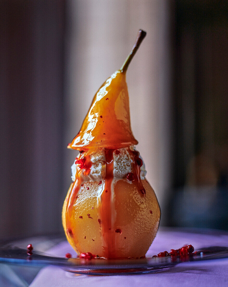 Pear with ice cream filling and pink peppercorn sauce