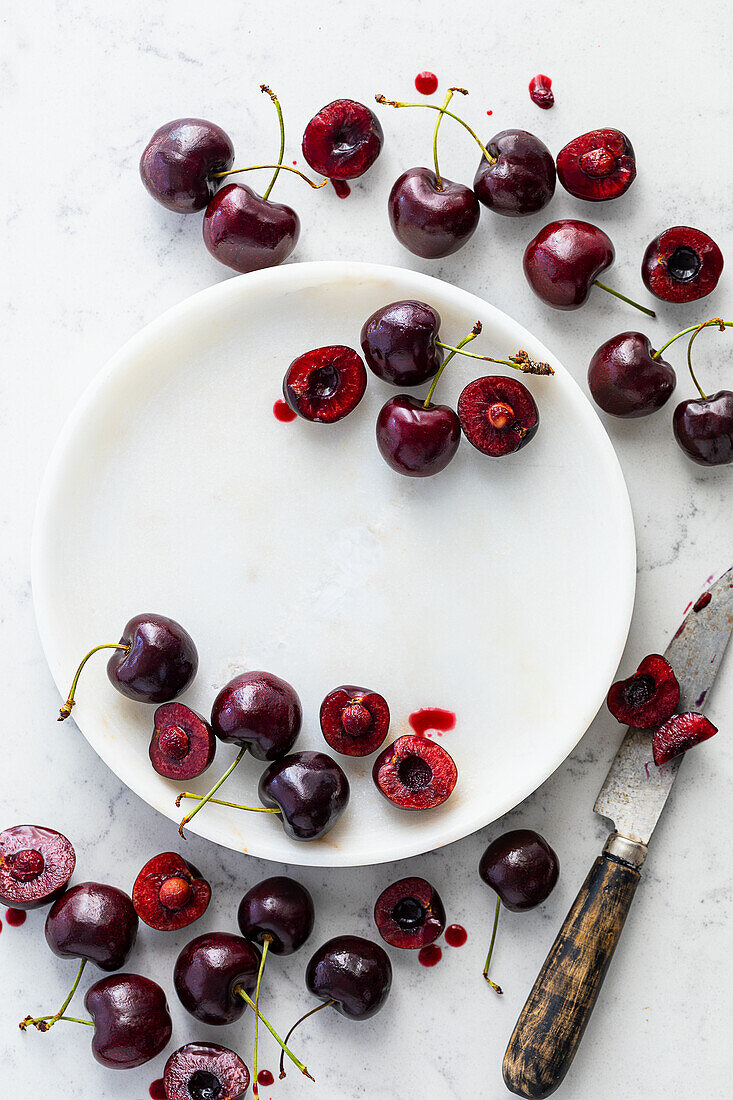 Fresh cherries with knife and white plate