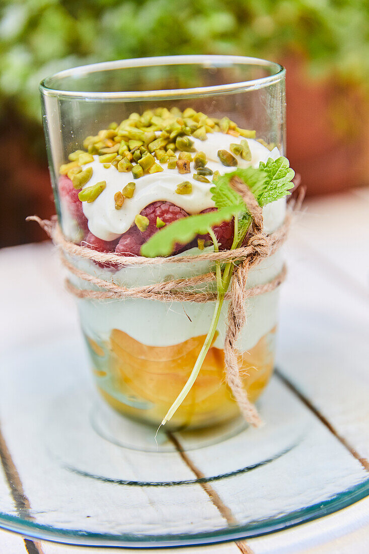 Trifle with oranges, cream, raspberries and pistachios