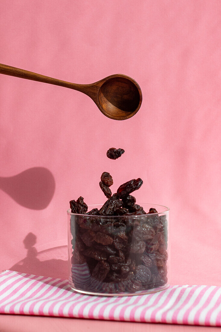 Falling raisins against a pink background
