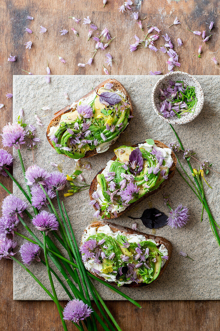 Toasted bread with cream cheese, avocado and chive blossoms