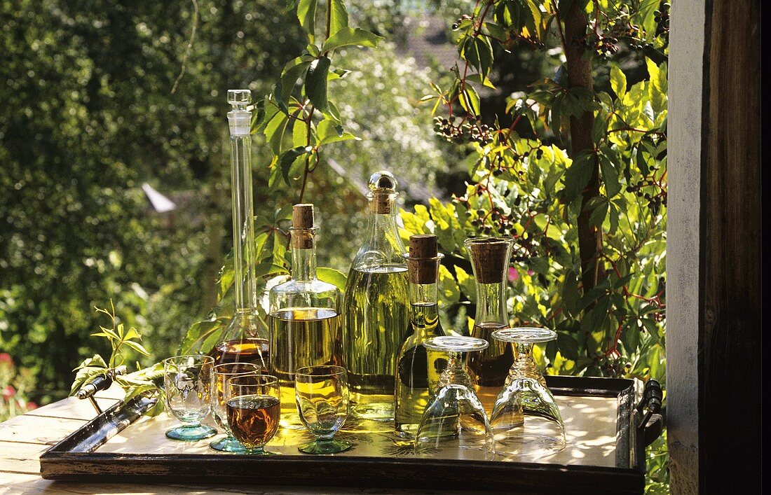 Home-made herb liqueurs on a table in the garden