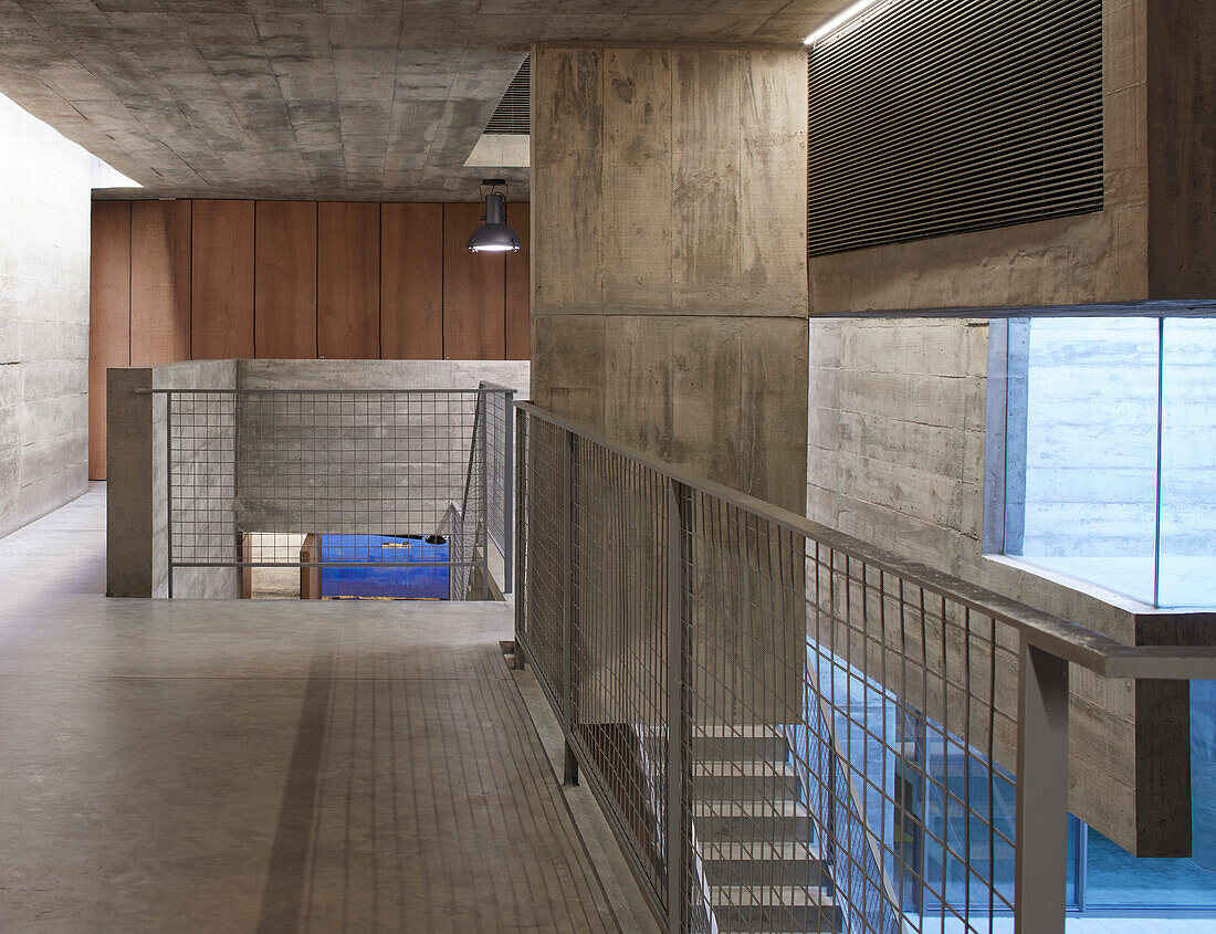 Staircase landing with metal balustrade in a concrete house