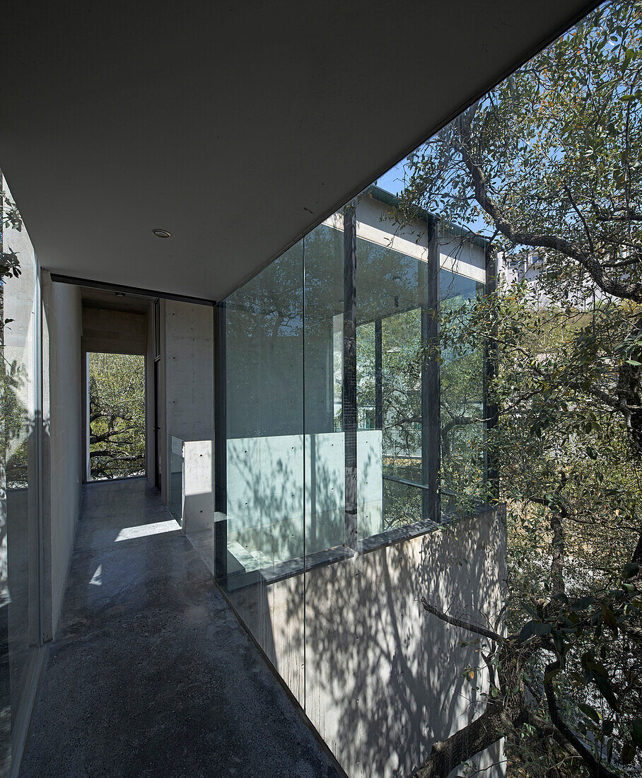 Hallway with glass walls in concrete house