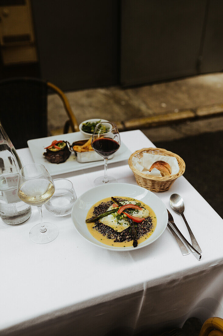 Schwarzes Risotto mit weißem Fisch