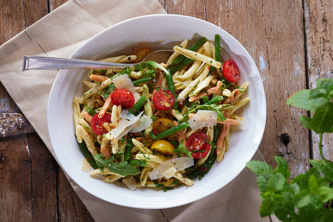 Pasta salad with cherry tomatoes, green beans, and parmesan cheese