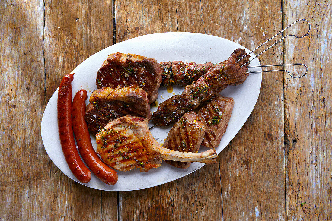 Grilled platter with sausages, pork chops, lamb kebab, and lamb chop