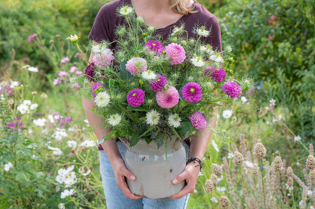 Bouquet of dahlias and maidenhair in clay pot