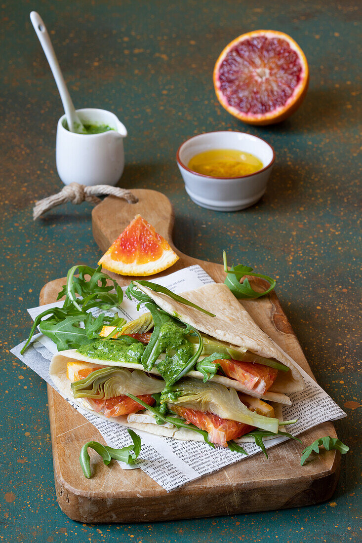 Piadina with artichoke, brie cheese, orange, arugula and pesto