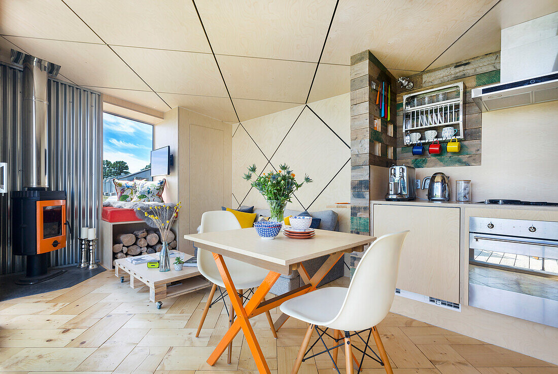 Bright, open-plan living room with small dining area and kitchen, diamond-shaped ceiling with LED strips