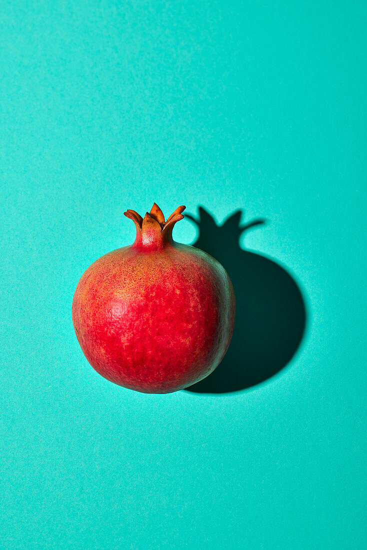 Pomegranate on turquoise background