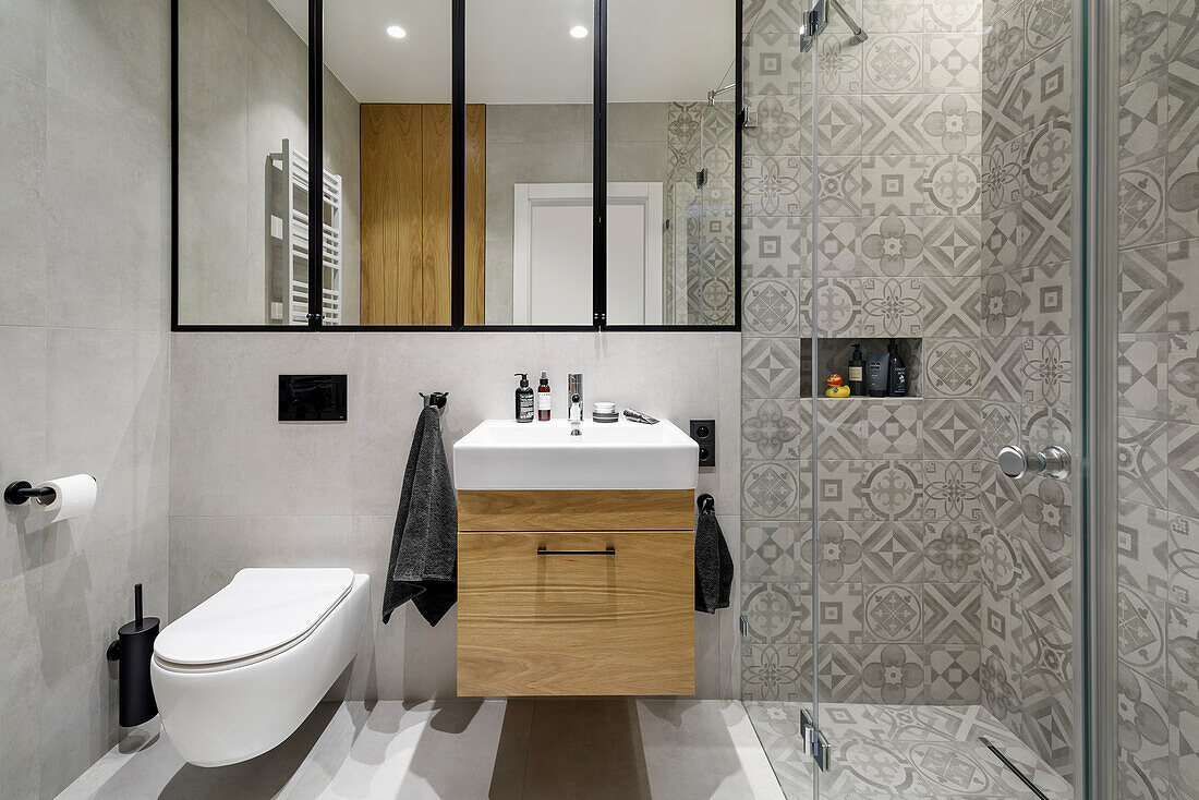Waschtisch und Duschbereich im Badezimmer in Grautönen mit Steingutfliesen