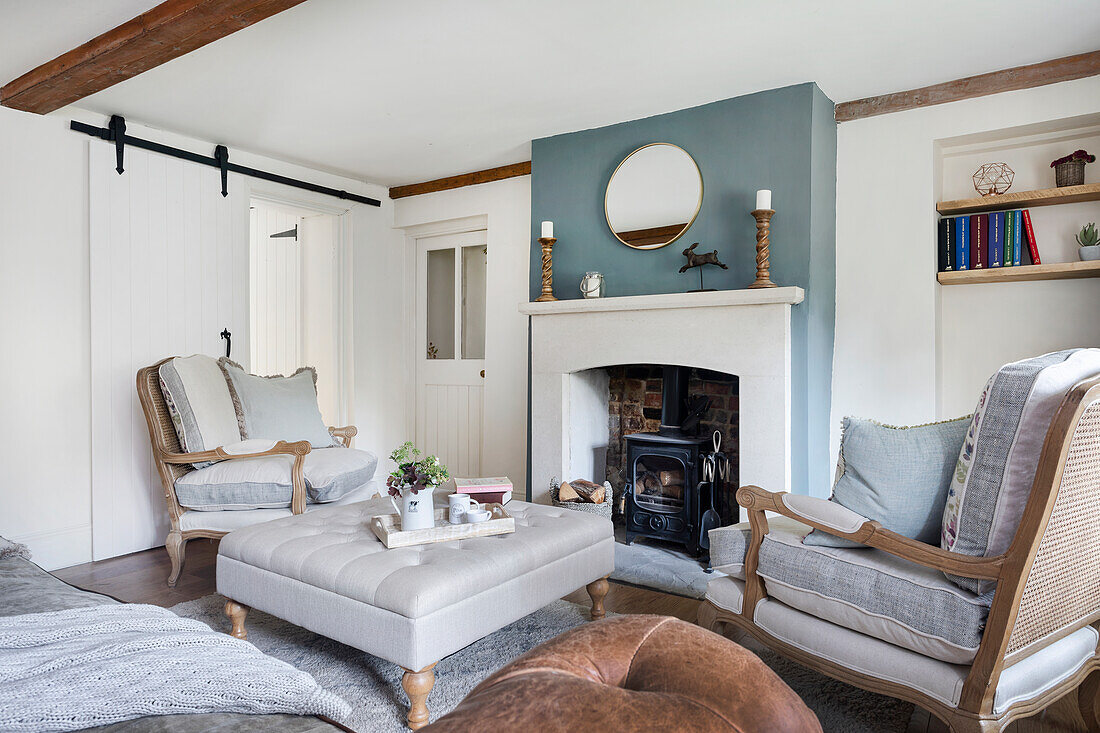 Seating and ottoman in front of fireplace with marble surround