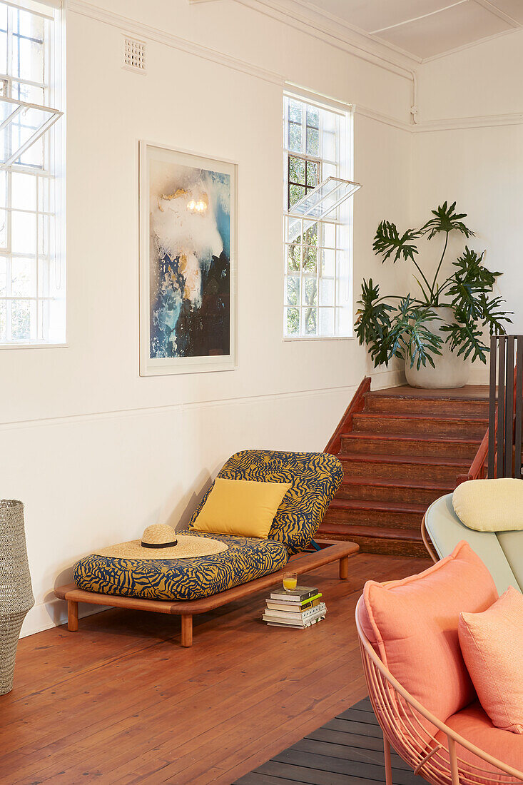 Lounger with patterned cover and houseplant in bright living room