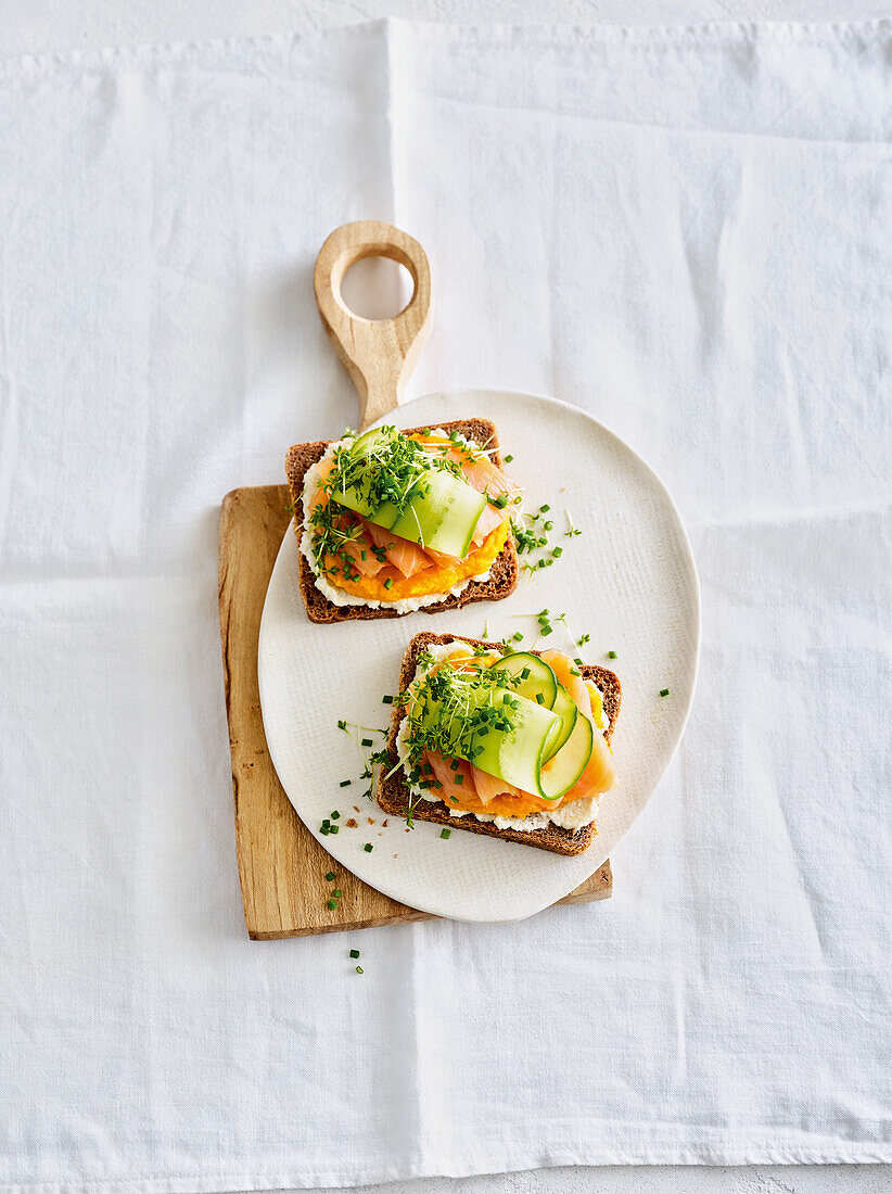 Buttered bread topped with salmon, carrot pâté and cucumber