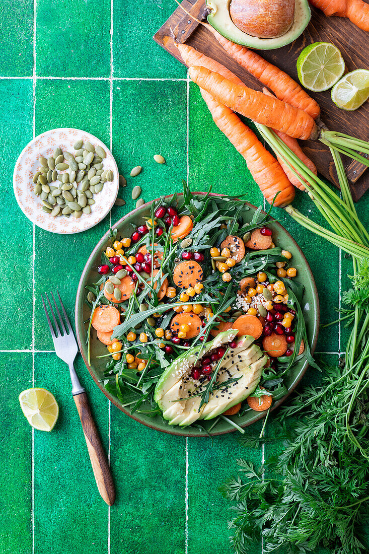 Carrot salad with rocket, avocado and pomegranate seeds