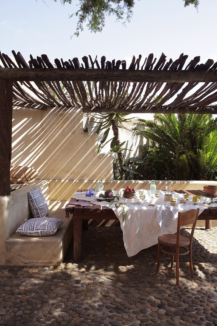 Gedeckter Tisch auf Terrasse mit Sonnenschutz