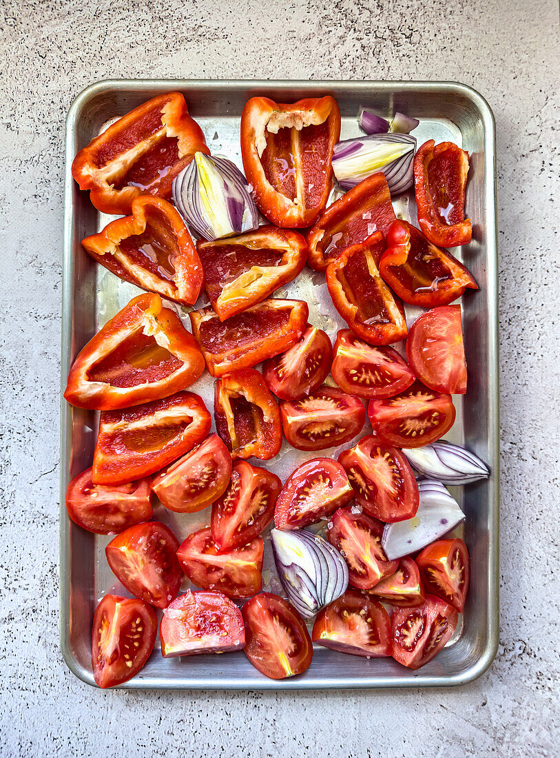 Tomatoes, peppers and red onions on roasting tray