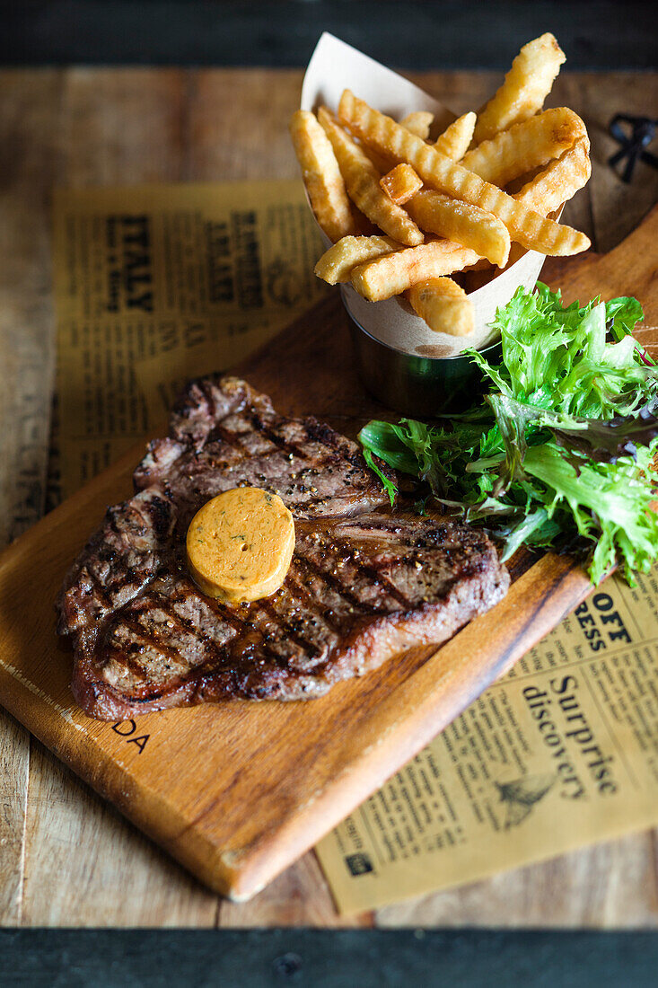 T-Bone-Steak mit Kräuterbutter und Pommes