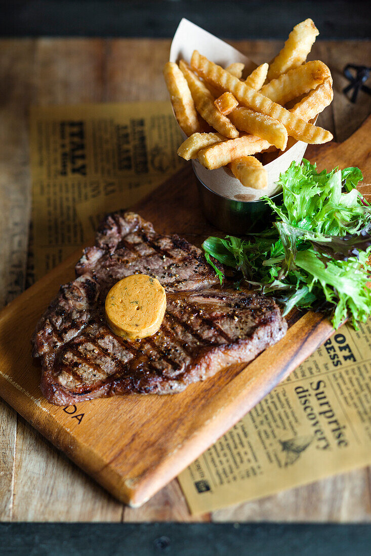 T-bone steak with herb butter and fries