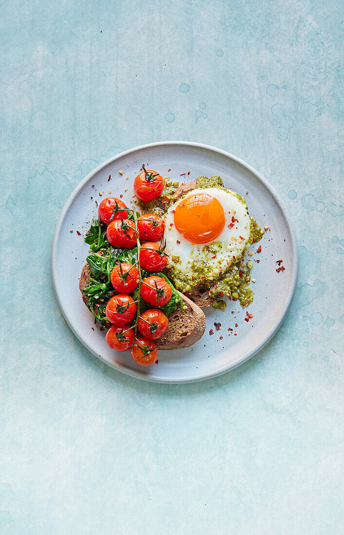 Toasted bread with pesto egg and baked tomatoes