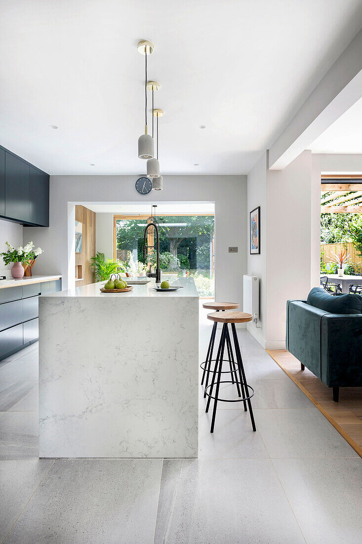 Kitchen island with bar stools in open-plan living room