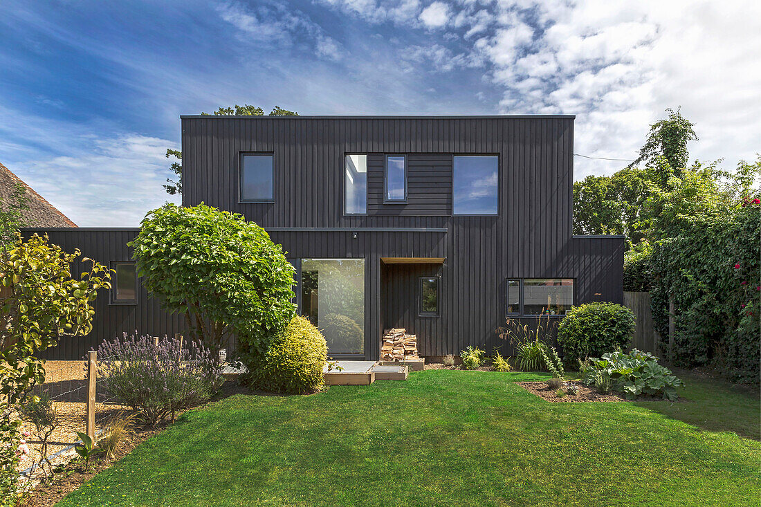 View of 70s house with black façade from the garden