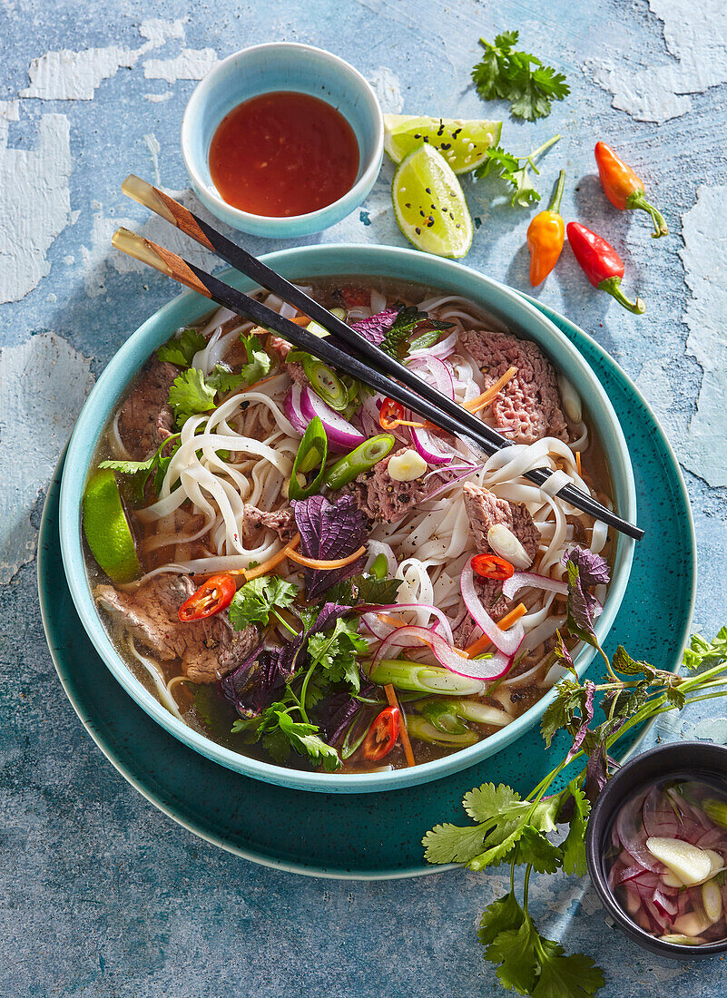 Asian beef soup with rice noodles and chilies