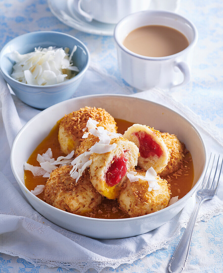 Kokosknödel mit Johannisbeerfüllung auf Mangosauce