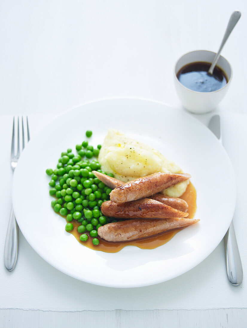 Sticky Schweinswürstchen mit Ahornsirup, Erbsen und Kartoffelpüree