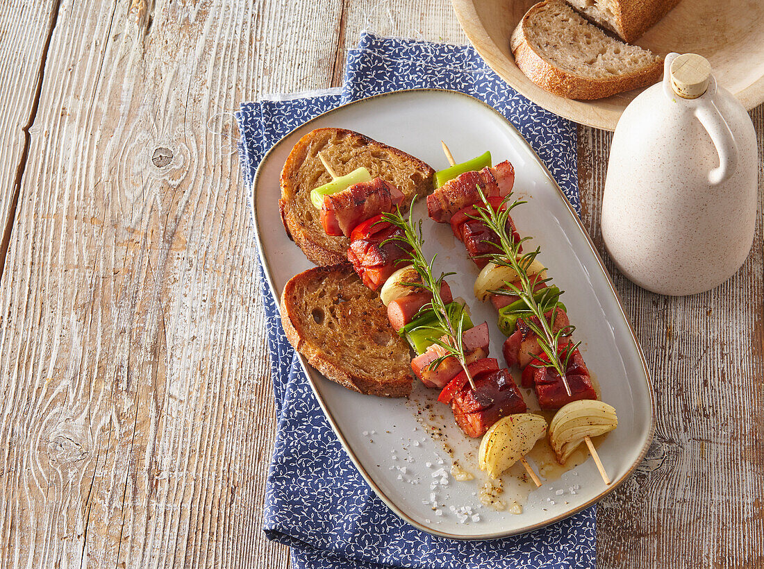 Meat skewers with ham, bacon and sausage