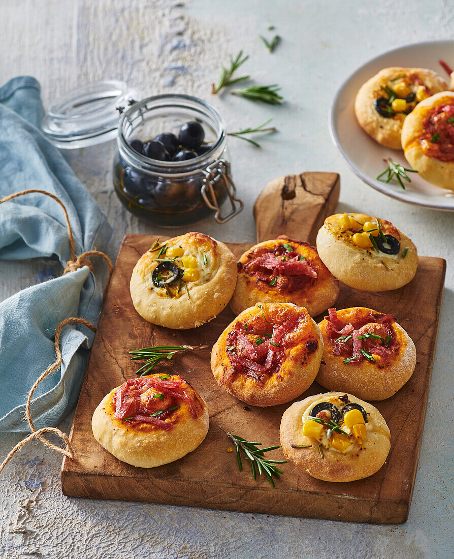 Mini pizzas with sausage, olives, and corn