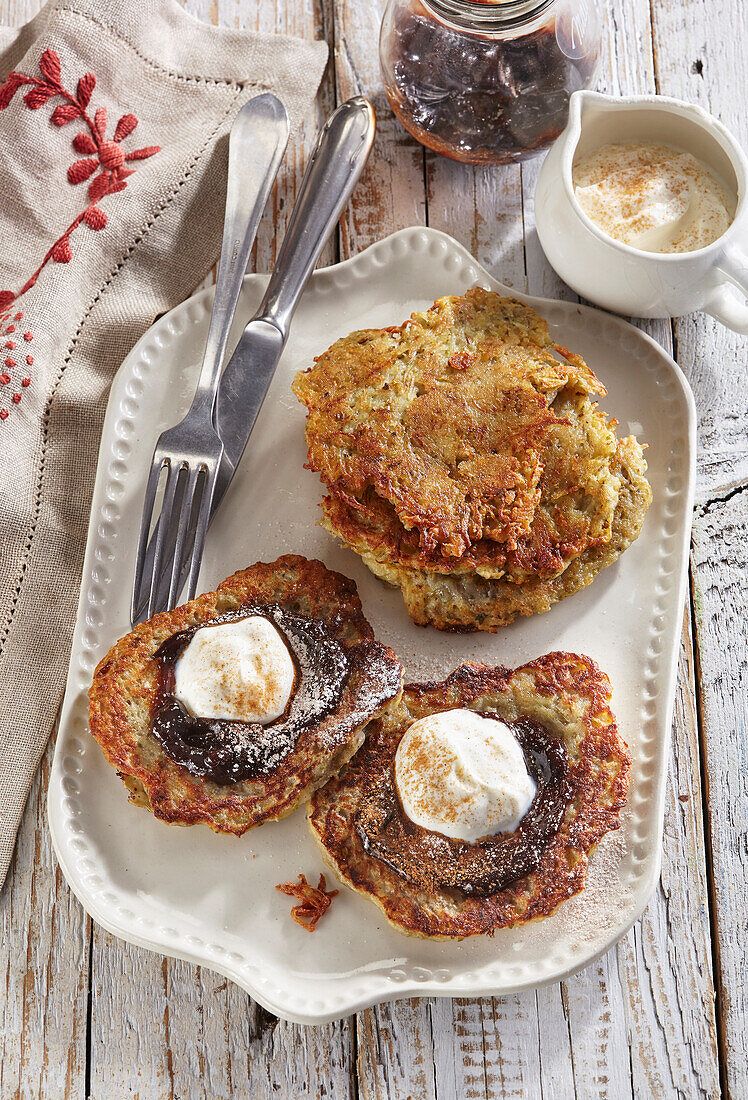 Small potato pancakes with plum puree and sour cream