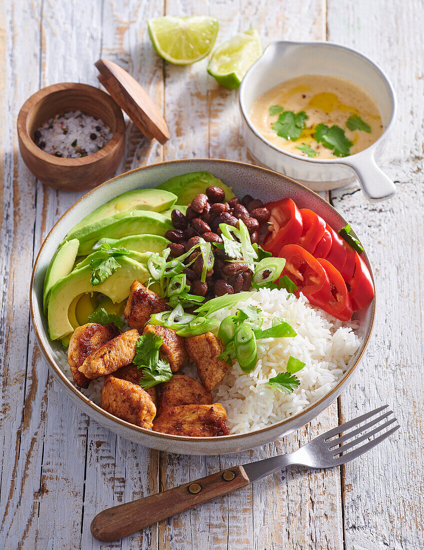 Burrito bowl with fried chicken, rice, and vegetables