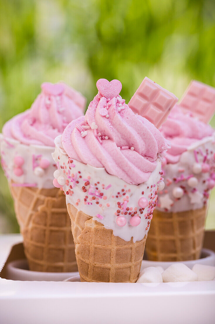 Ice cream cone with pink buttercream and sugar sprinkles