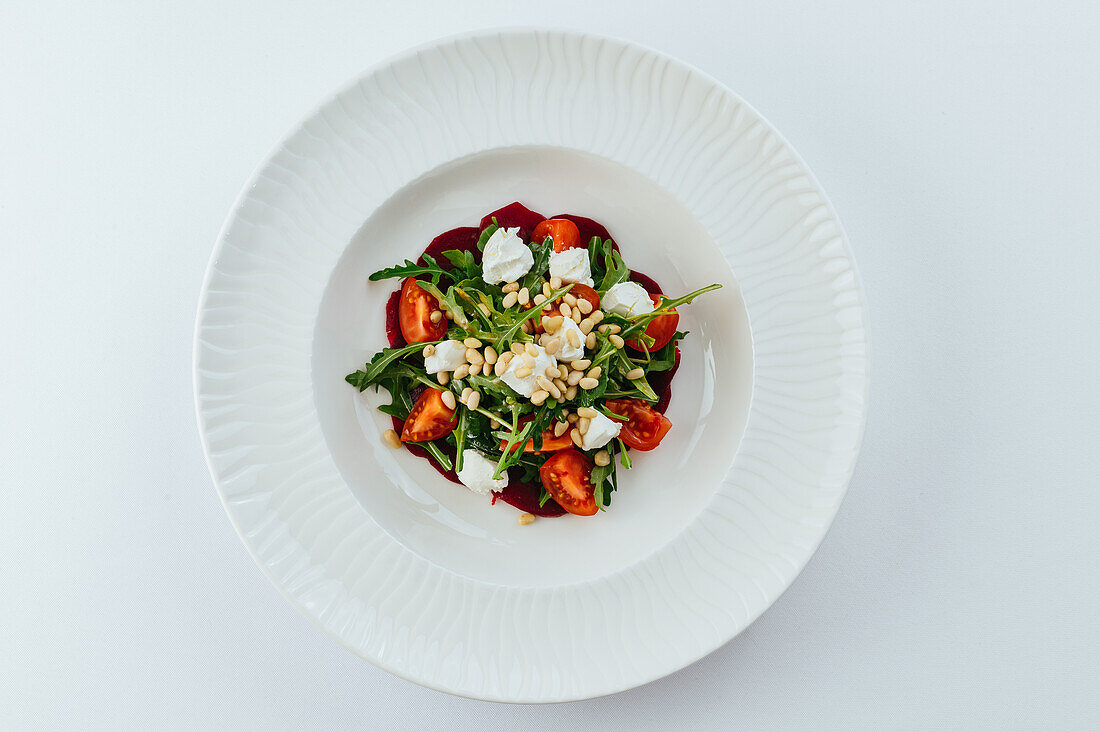 Arugula salad with tomatoes, mozzarella and pine nuts