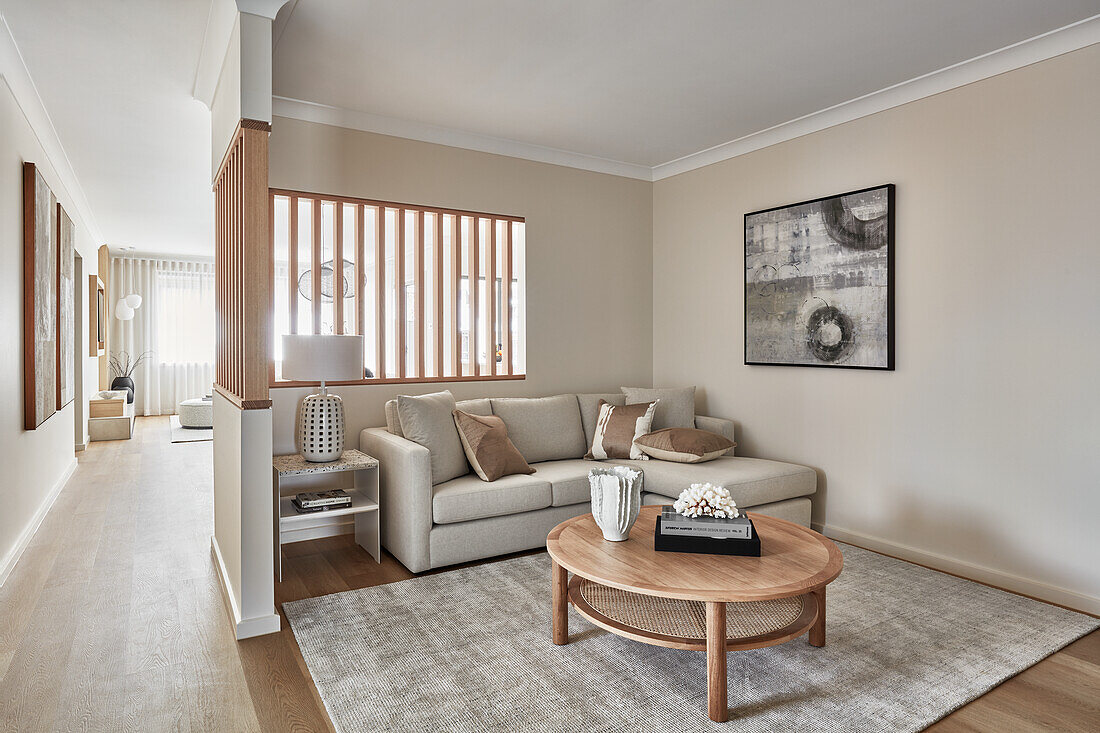 Modern coastal style home with cream sofa and round wooden coffee table