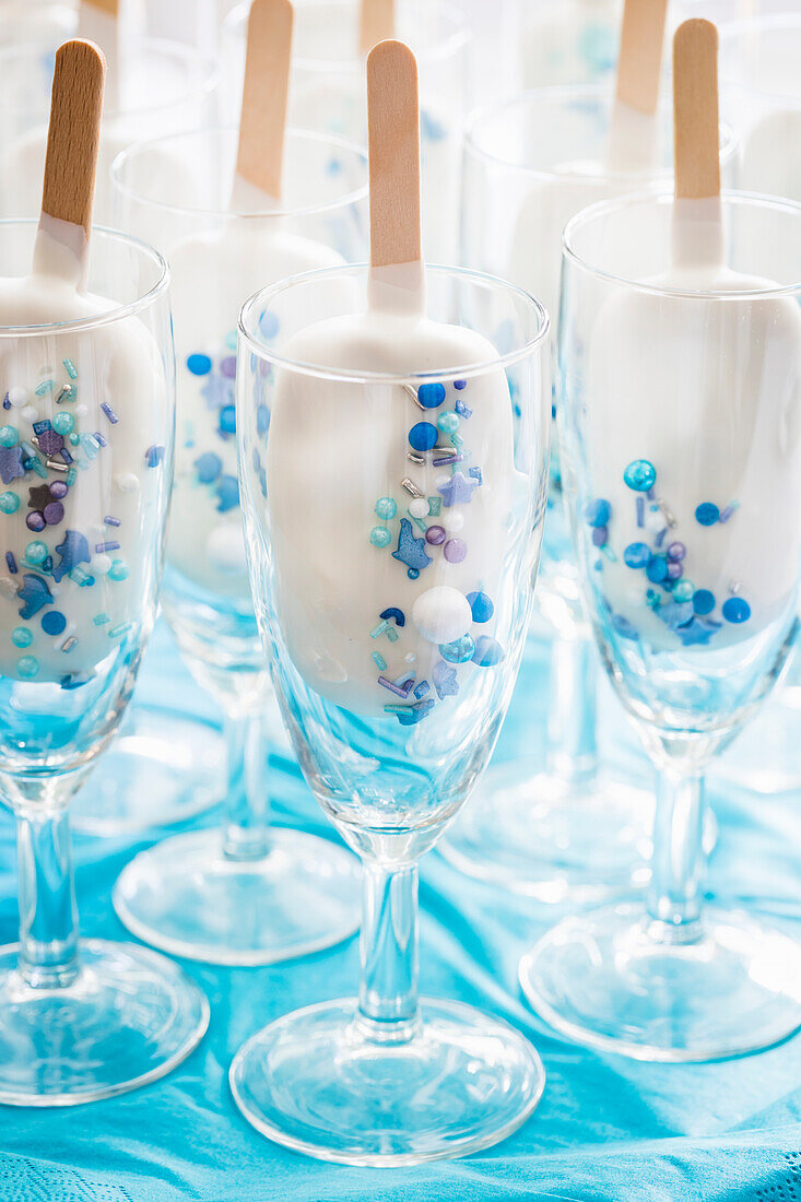 Weiße Cake Lollies mit blauen Zuckerstreuseln