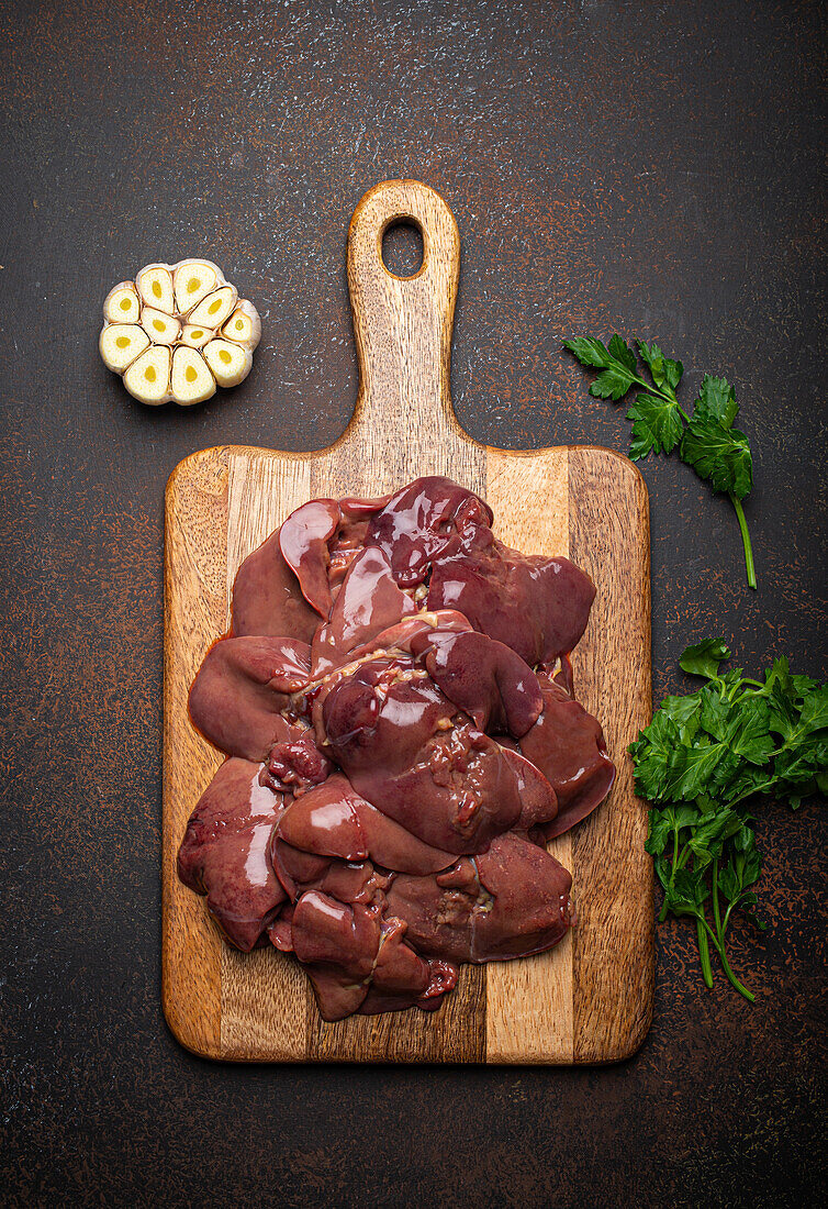 Raw chicken liver on wooden cutting board