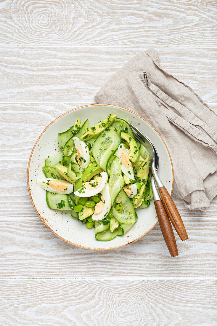 Green salad with avocado, cucumber, edamame and a boiled egg
