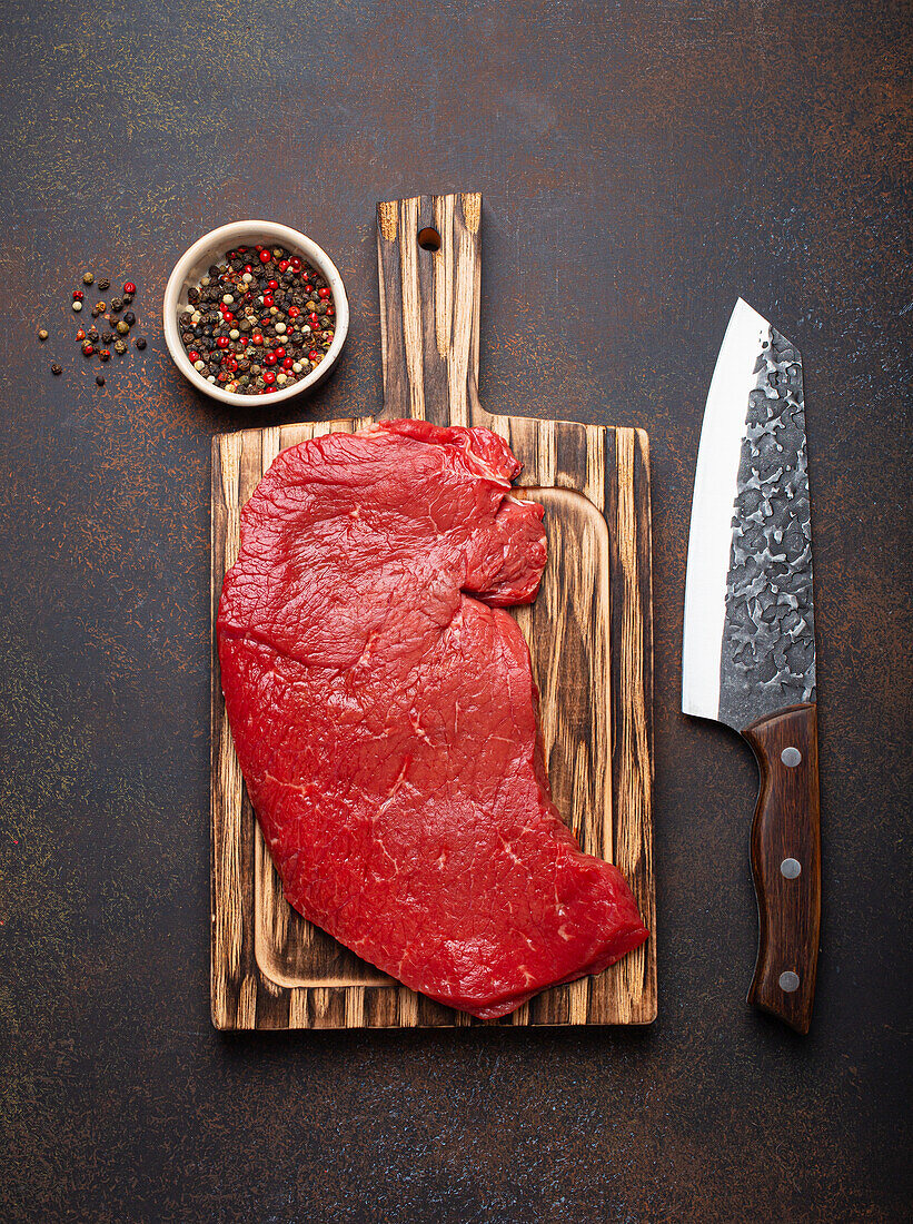 Raw beef steak on a wooden cutting board