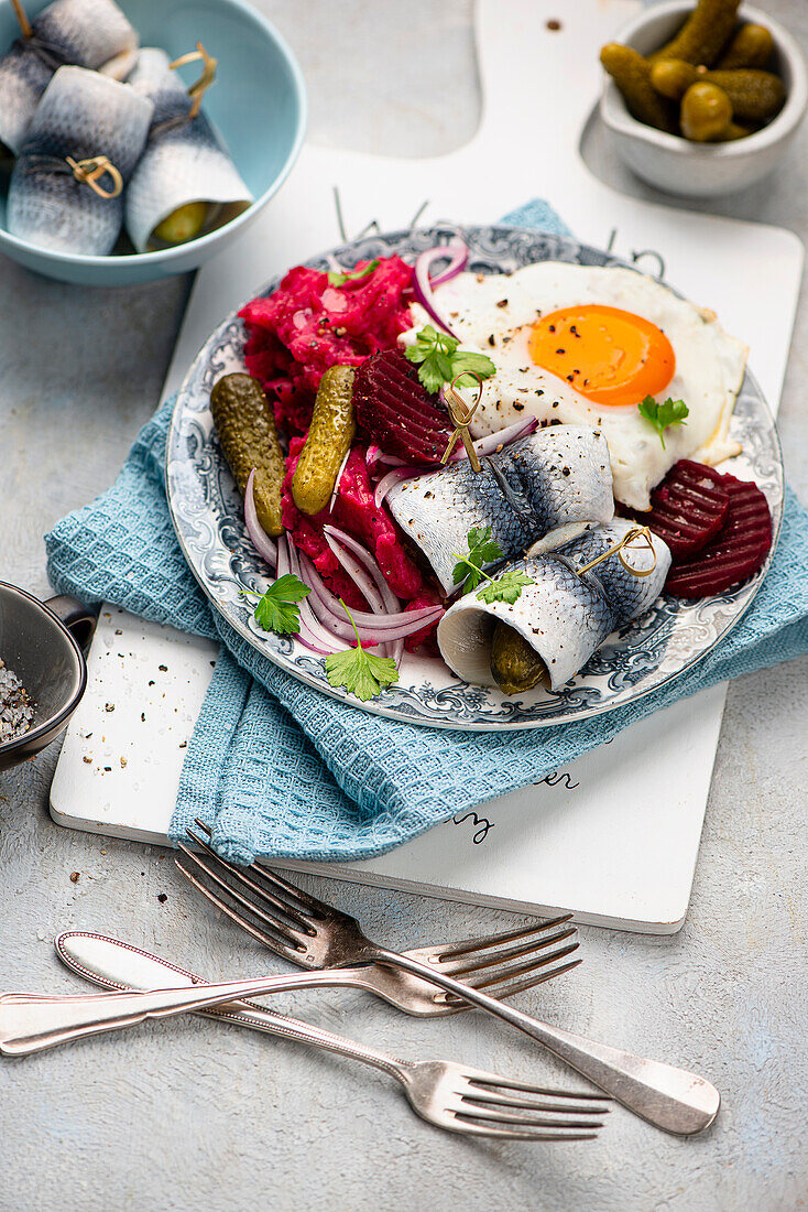 Labskaus mit Gewürzgurken, Rollmops und Spiegelei