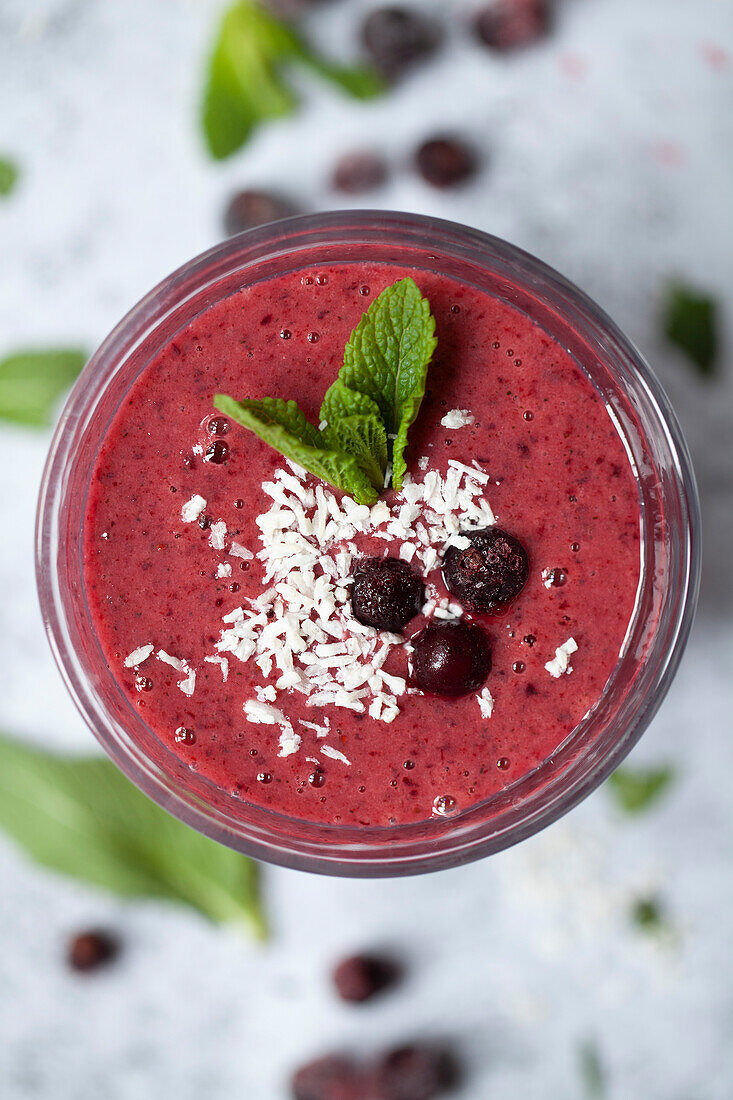 Blackcurrant smoothie with blackcurrants, mint and coconut flakes