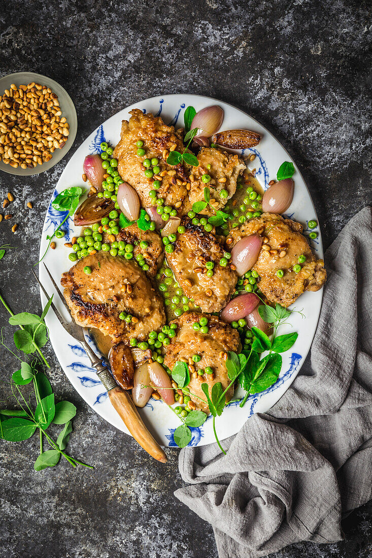 Chicken cutlets with shallots, peas, pea shoots and roasted pine nuts