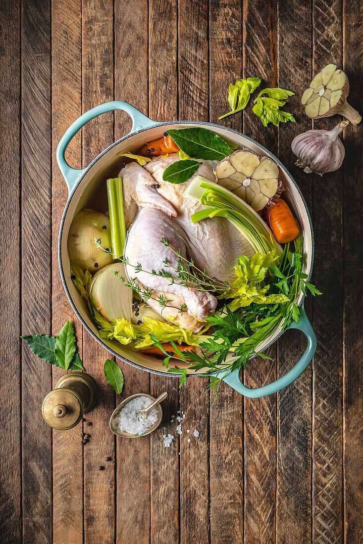 Raw chicken with vegetables in a dutch oven for chicken broth