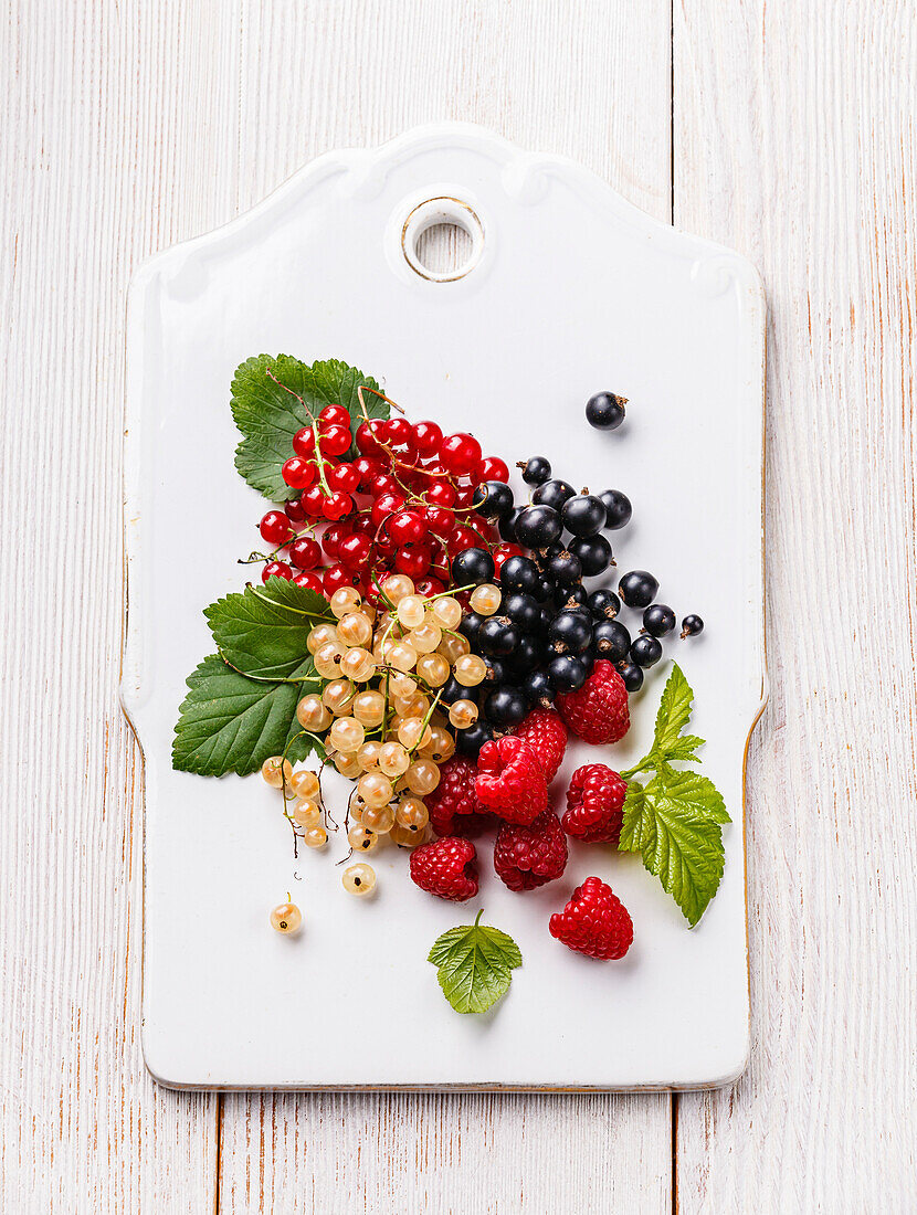 Fresh berries with leaves on rustic wooden background