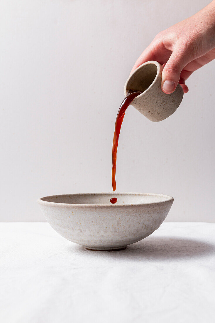 Kaffee in eine Keramikschale gießen