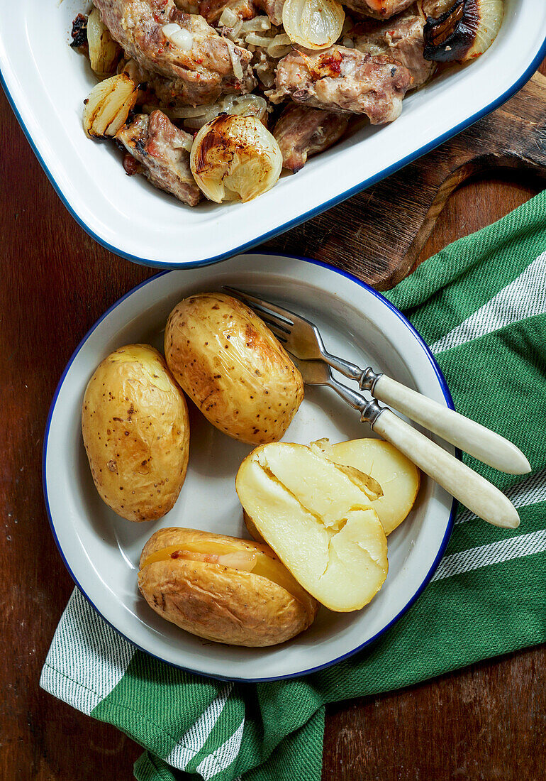 Pork ribs baked in the oven with onions, baked jacket potatoes