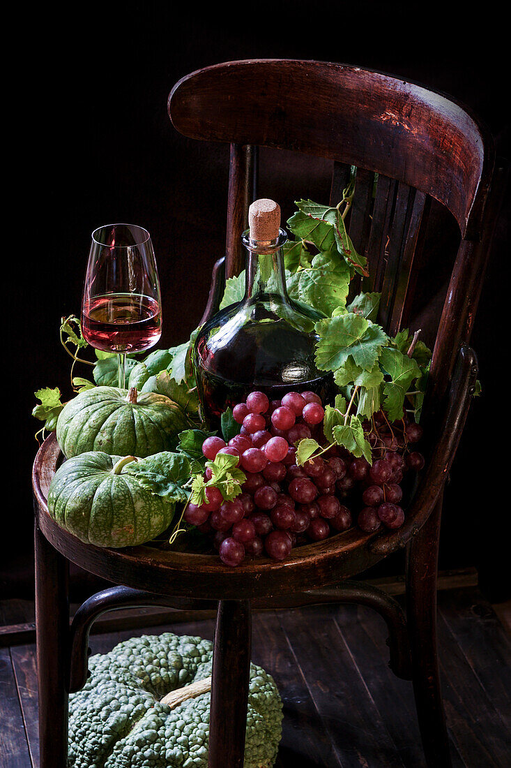 Herbststillleben mit Wein, grünen Kürbissen und Trauben