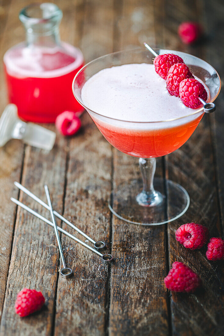 Raspberry cocktail with raspberry syrup and raspberry skewers
